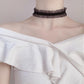 Vintage lace choker necklace displayed on a neck form against a plain backdrop