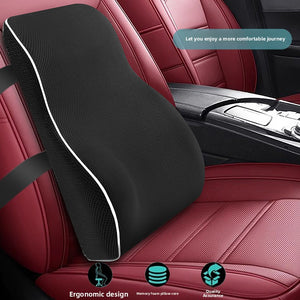 Black memory foam back cushion strapped to a red leather car seat inside a vehicle