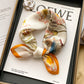 Cream floral printed square scarf with a satin sheen and hemmed edges, shown displayed and knotted