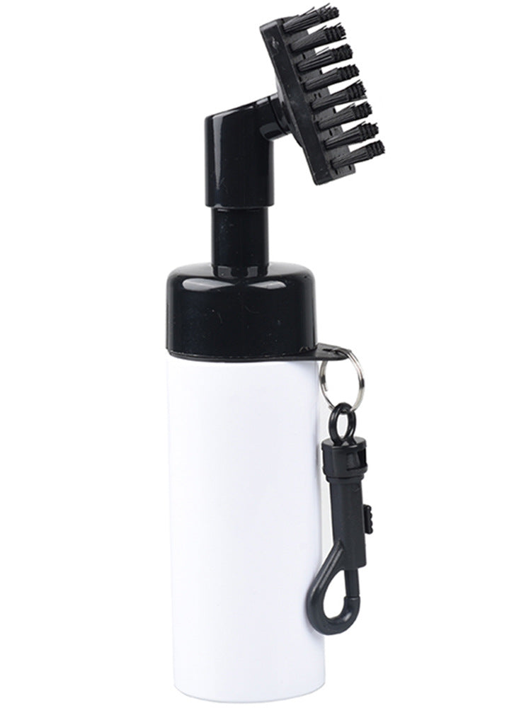 Black golf cleaning spray brush clipped to a golf bag by its buckle