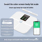 White body fat scale at an angle beside a phone showing the companion app readings