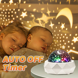 Rotating star projector casting colored stars and a moon across a dark ceiling