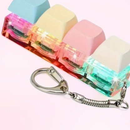 Macaron pastel keycap clicker keychain, four lit switches on a steel keyring with spring chain