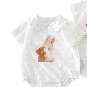 Close up of the baby romper front showing a watercolor rabbit and teddy bear on gray dotted cotton