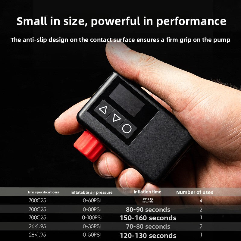 Hand holding the black electric air pump showing the red knob, three buttons and LED display, with a tire inflation table