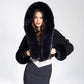 Black faux fur hooded cropped jacket with long pile trim framing the hood on a model
