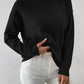 Black half-high neck pullover sweater with long sleeves worn with white trousers, size M variant image