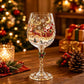 Clear wine goblet with a painted holiday sled design on the glass bowl
