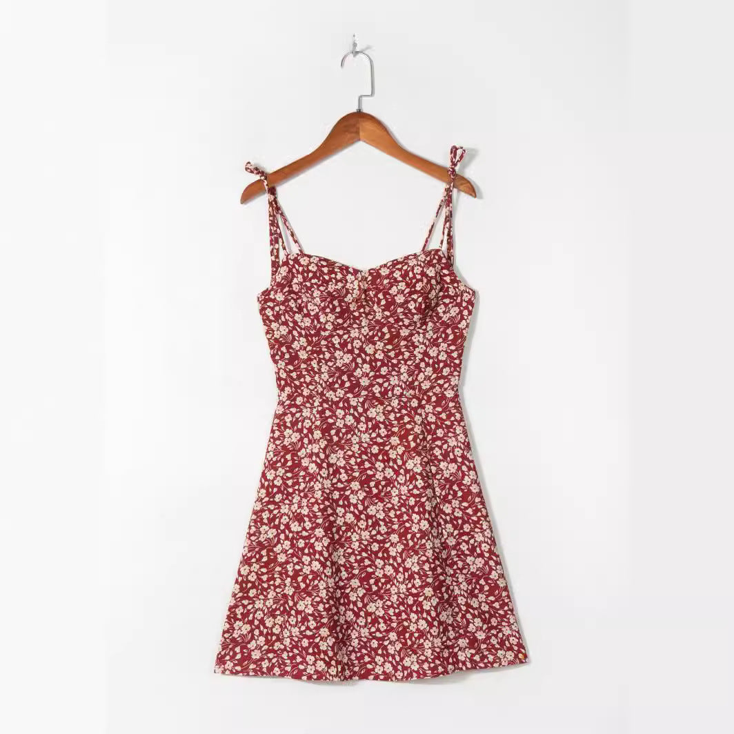 Wine red ditsy floral strap mini dress shown on a wooden hanger
