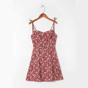 Wine red ditsy floral strap mini dress shown on a wooden hanger