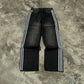 Baggy side-stripe washed denim jeans worn on the move with a travel bag