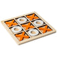 Wooden tic tac toe board with orange crosses and white rings set in the sunken grid, angled view