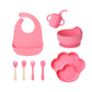 Dark pink 8-piece baby feeding set with a bib, a sippy cup, a bowl, four utensils and a bear paw plate
