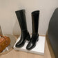 Black riding boot side view with a thick rubber sole and stacked block heel