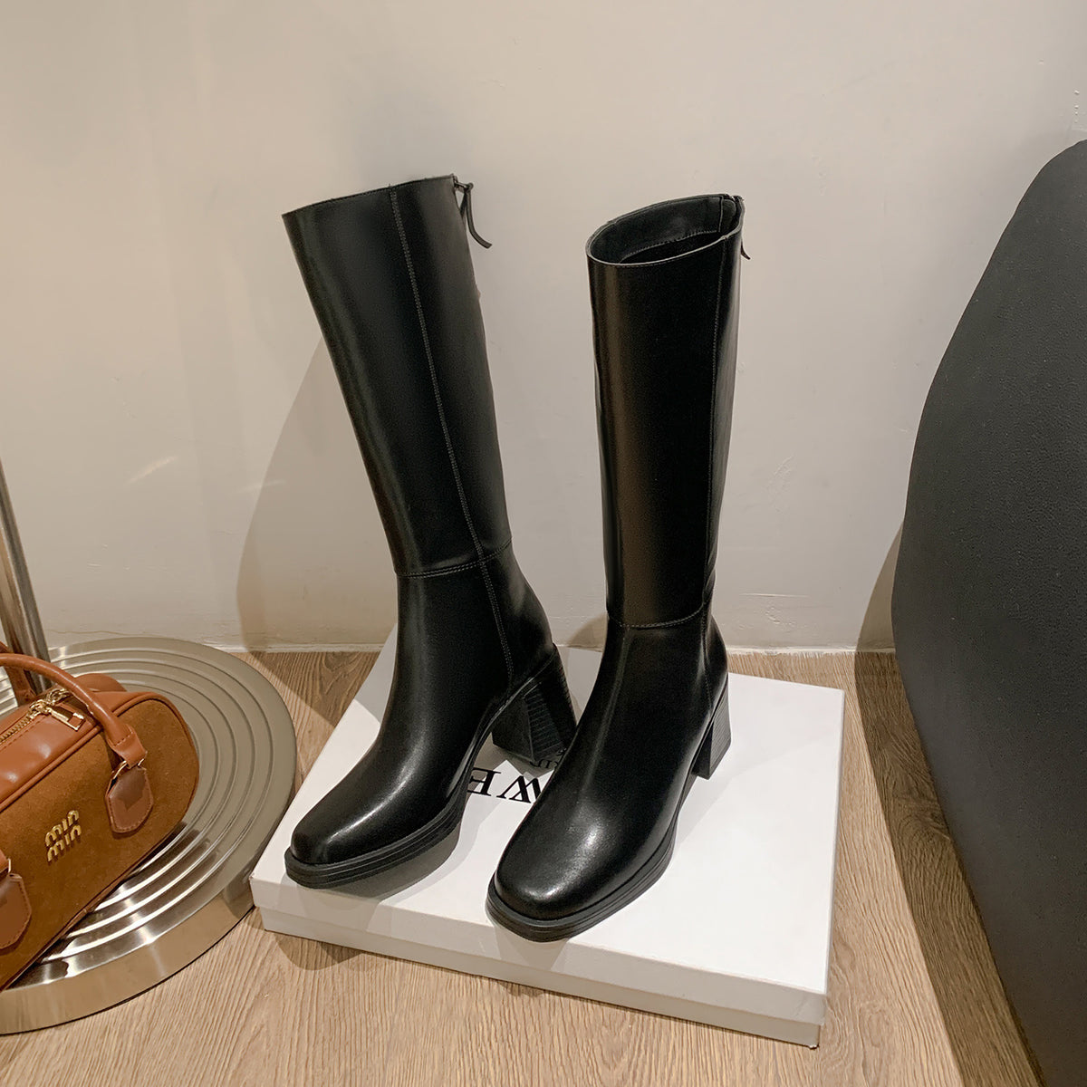 Black riding boot side view with a thick rubber sole and stacked block heel