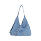 Denim shoulder bag with a single wide strap carried at the hip