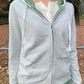 Woman wearing the green striped zip-up hoodie, model photo for the Green Stripe one size option