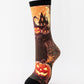 Mid-calf sock on a mannequin printed with an orange haunted house on a hill and a grinning pumpkin
