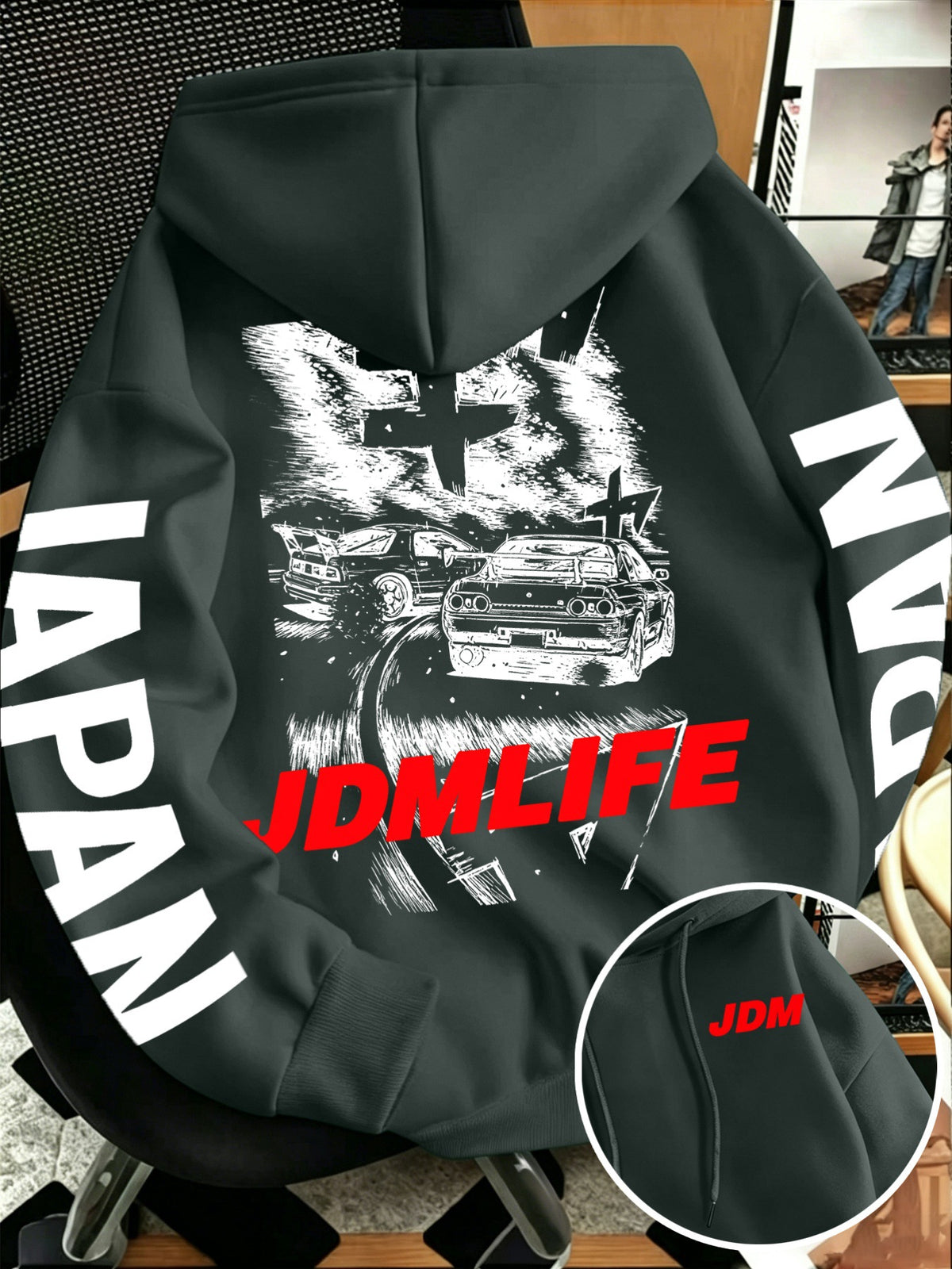Front pocket detail of the JDM hoodie with a small red JDM tag beside the pouch pocket