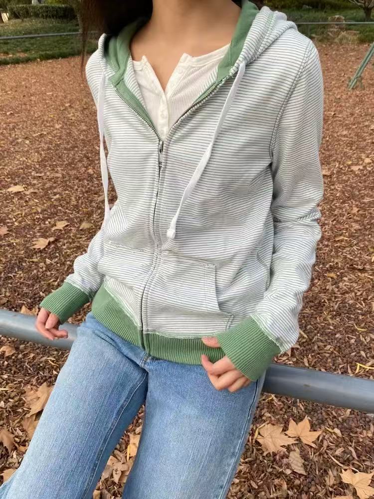 Green striped zip-up hoodie with kangaroo pocket and ribbed green hem and cuffs, worn with jeans