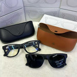 Two black MT5 smart glasses with clear and tinted lenses beside black and brown leather charging cases