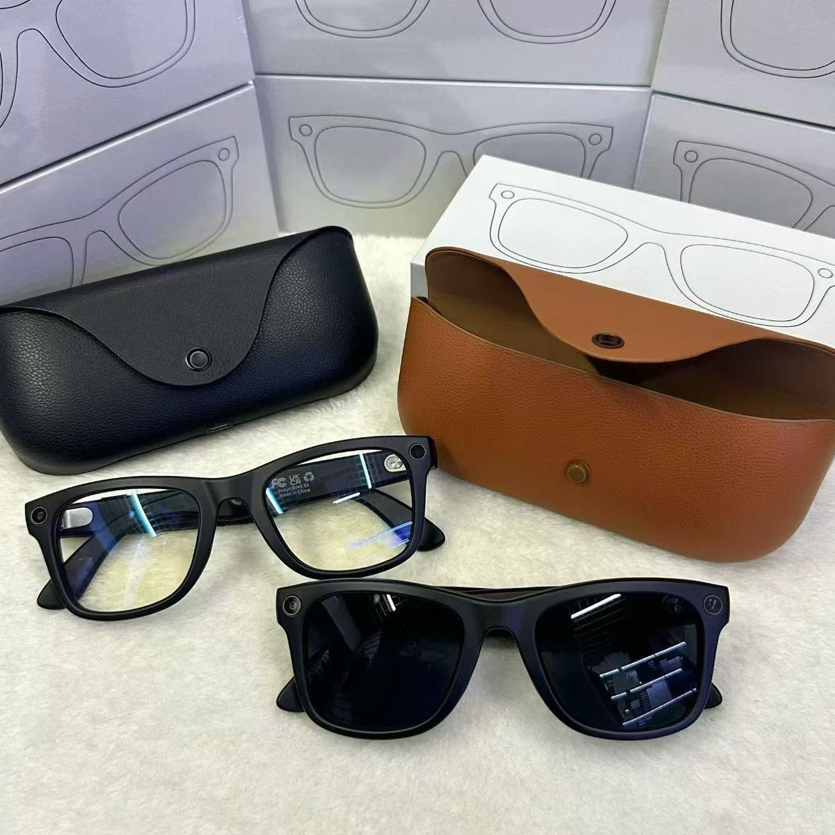 Two black MT5 smart glasses with clear and tinted lenses beside black and brown leather charging cases