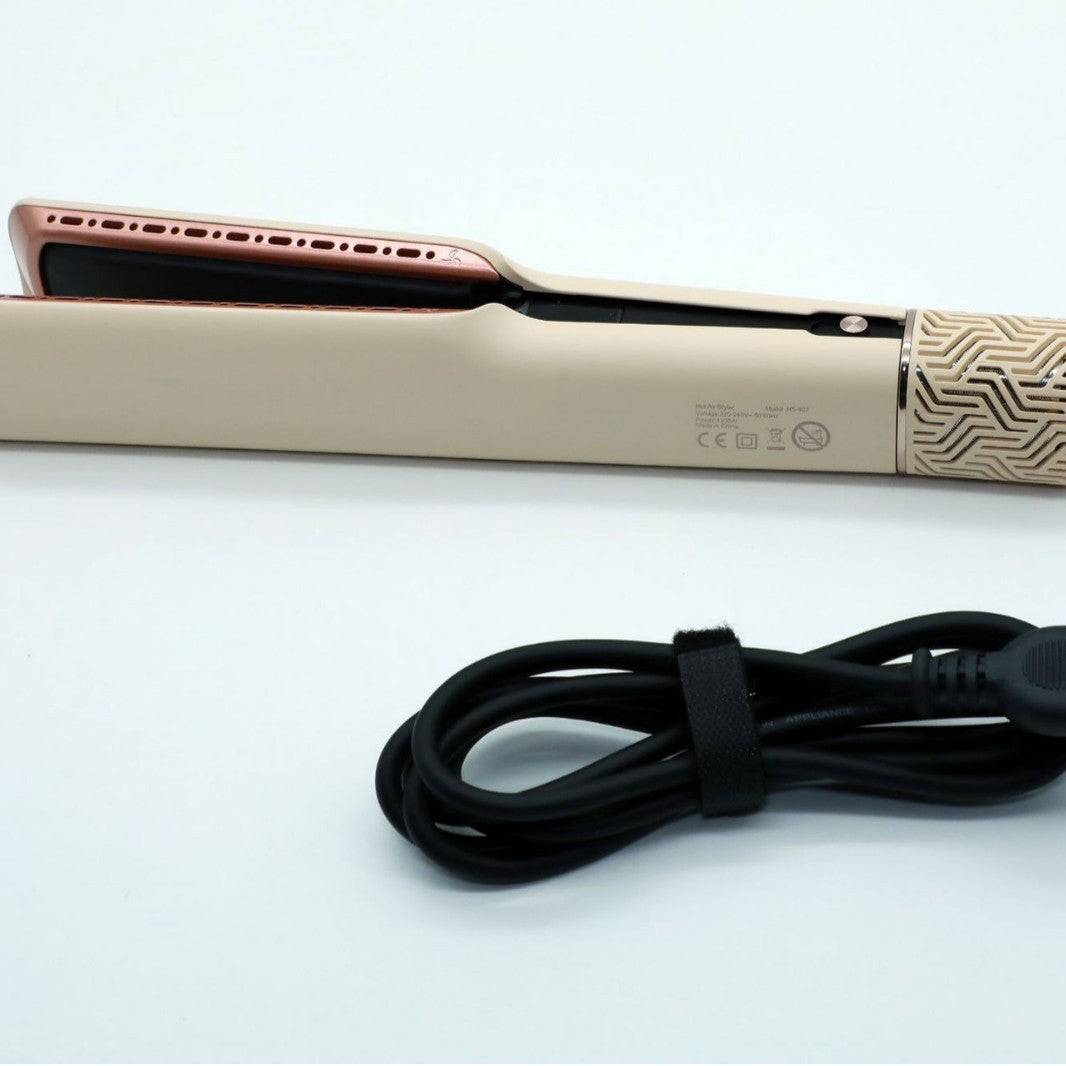Hair straightener side view with rating label and coiled black power cord