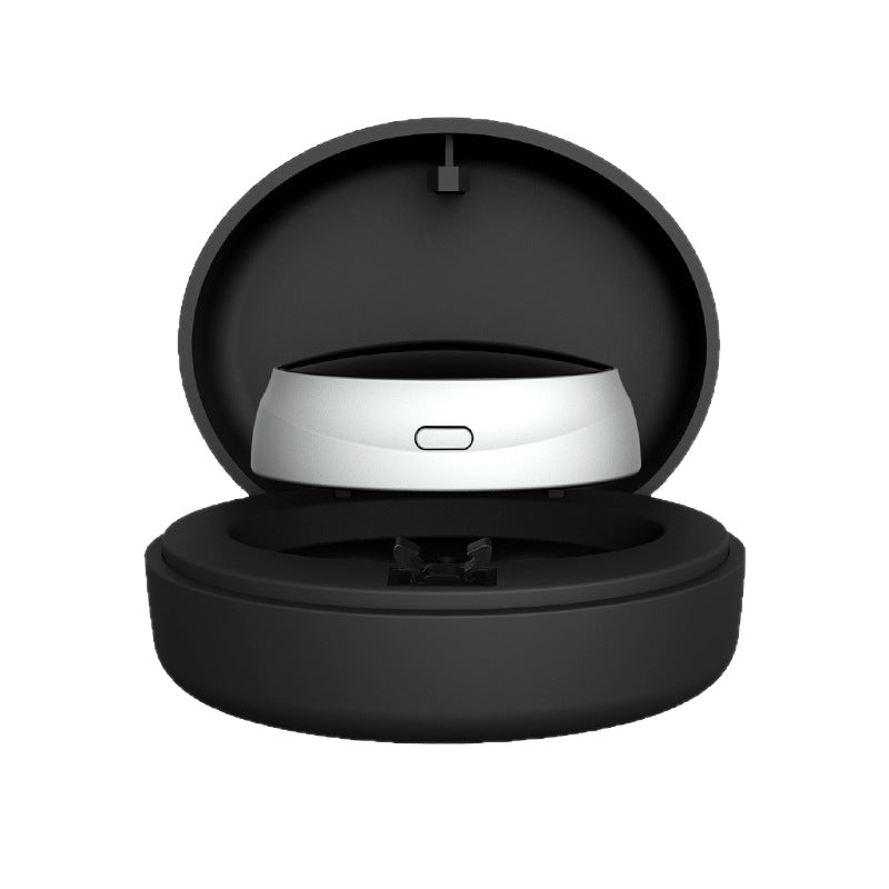 Silver throat pulse device seated inside its open round black charging case