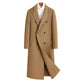 Camel double breasted long wool blend coat on a wooden hanger over a white roll neck, front view