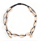Cowrie shell choker on black cord laid flat on white, macrame sliding knot visible at the top