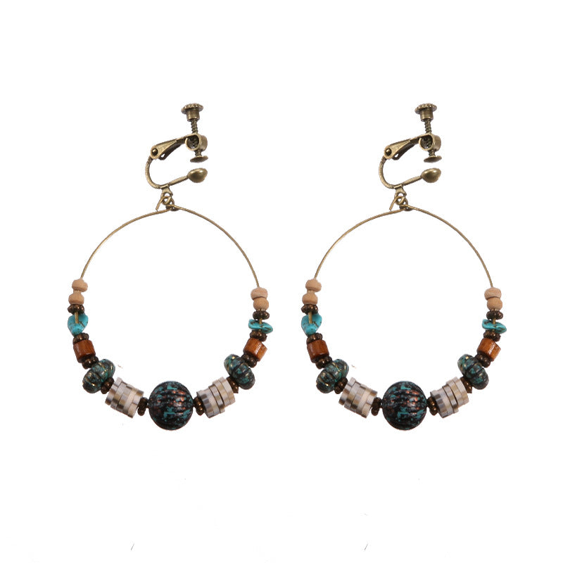 Handmade bohemian clip-on earrings with tassel and bead drop detail, zinc alloy frame, studio shot on white background
