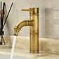 Antique copper bamboo basin faucet with a curved neck spout on a marble bathroom counter