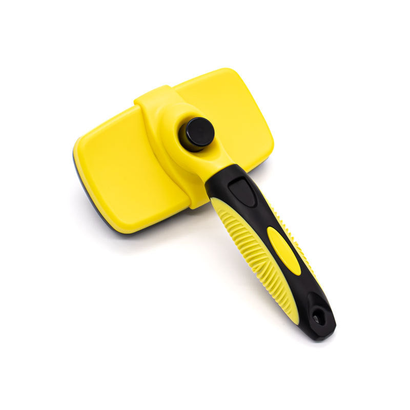 Yellow self cleaning pet slicker brush shown at an angle with its ergonomic non slip handle