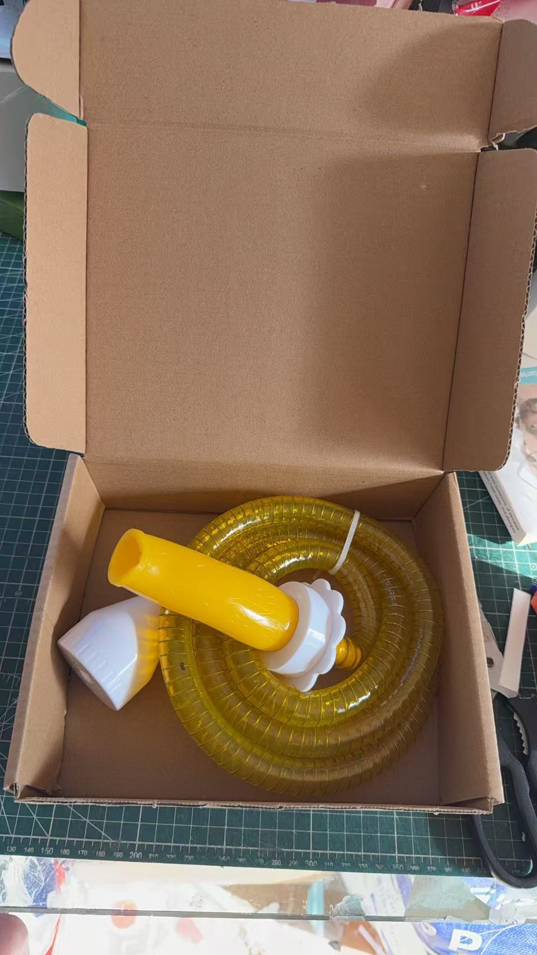 Pet shower hose connector shown next to its color box packaging