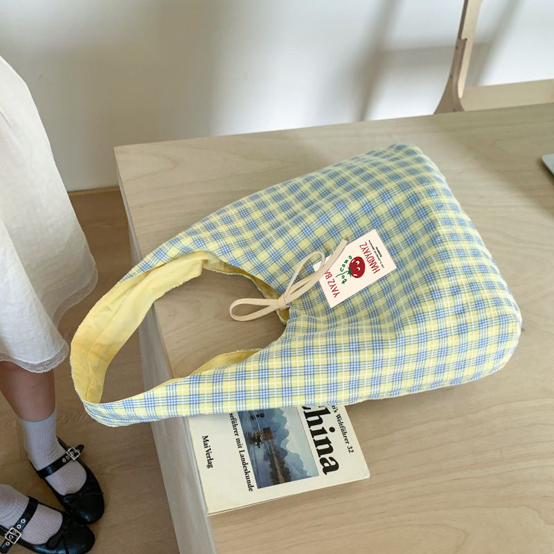 Open top of a plaid canvas shoulder bag showing the polyester lining