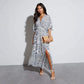 Ivory and cobalt paisley print maxi dress worn walking with a straw clutch, White blue colourway