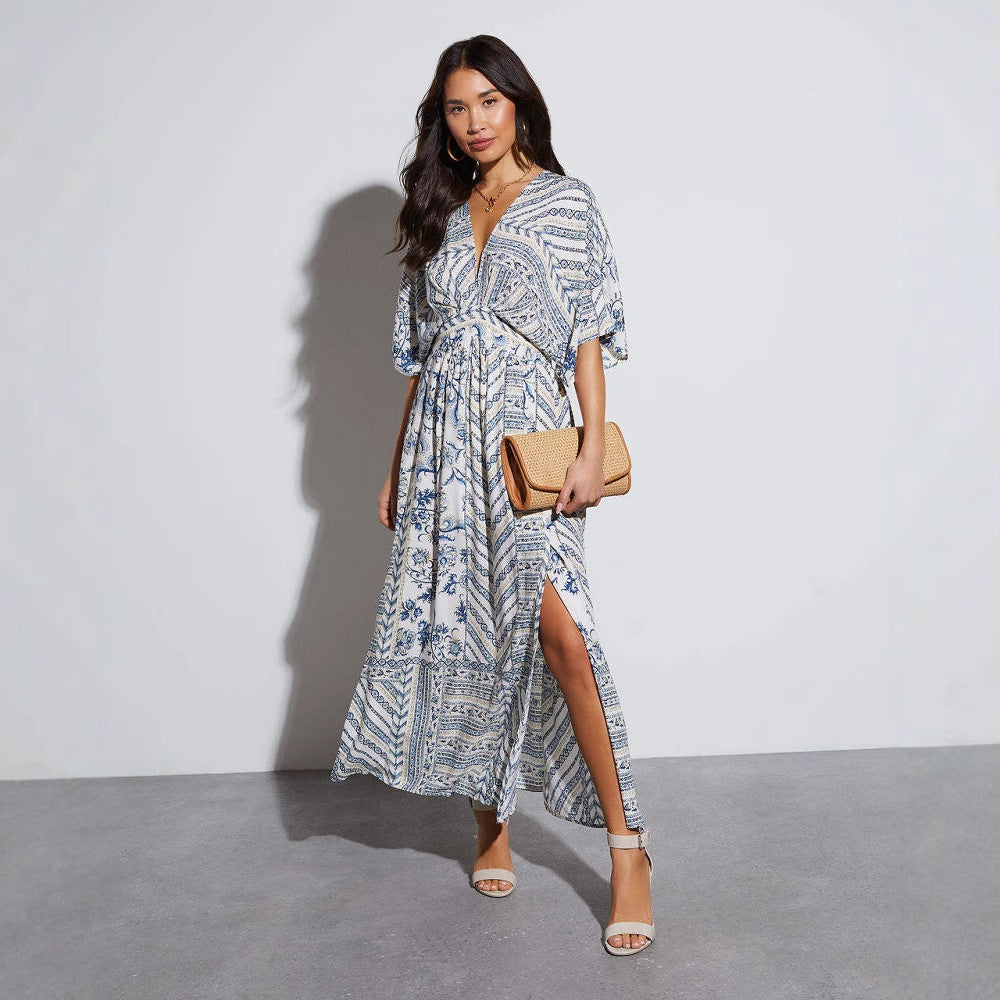 Ivory and cobalt paisley print maxi dress worn walking with a straw clutch, White blue colourway