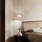 Rounded travertine stone pendant light on a slim cord in a warm wabi sabi interior