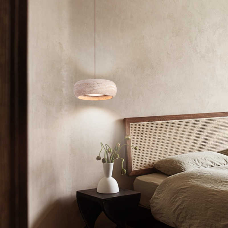Rounded travertine stone pendant light on a slim cord in a warm wabi sabi interior