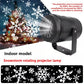 Black LED snowflake projector on a stand casting white snowflakes across a dark scene
