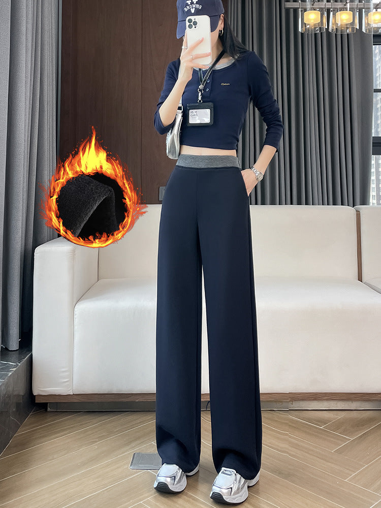 Woman in navy high-waisted wide-leg pants with a gray waistband and a flame graphic marking the fleece lining