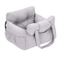 Padded car seat pet bed with raised bolster walls, carry handles and an inner clip with a small dog resting inside on a car