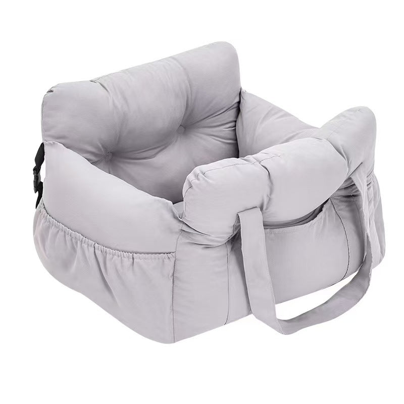 Padded car seat pet bed with raised bolster walls, carry handles and an inner clip with a small dog resting inside on a car