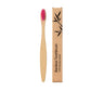 Bamboo toothbrush standing upright in a cup by the bathroom sink