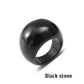 Black stone ring with a smooth domed face on a white background