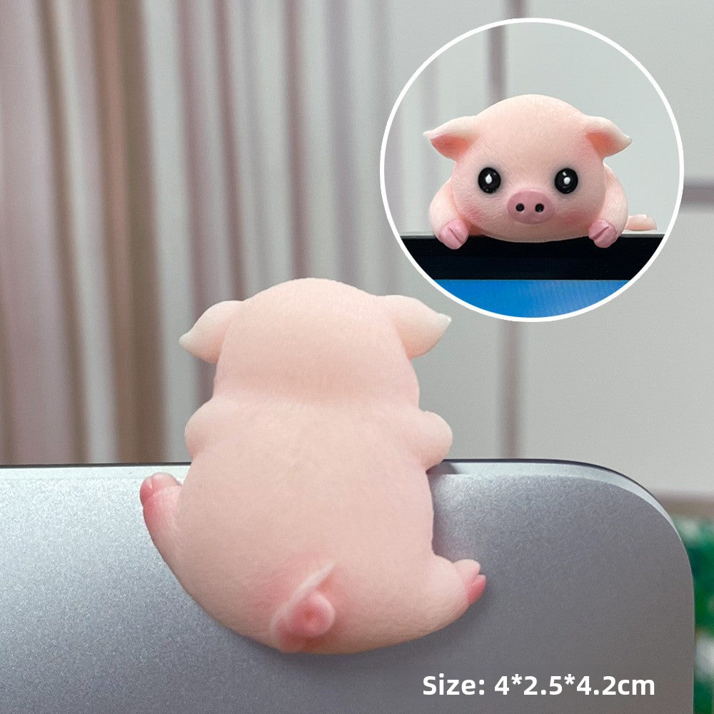 Pink pig resin figurine seen from behind on a laptop edge with a front view inset