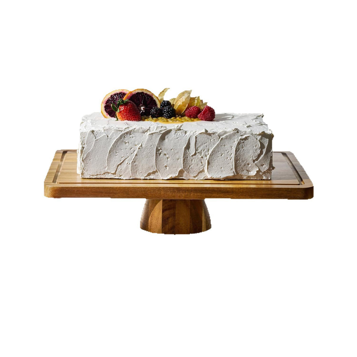 Rectangular acacia wood cake tray on a turned pedestal base holding a white frosted cake with berries and orange slices