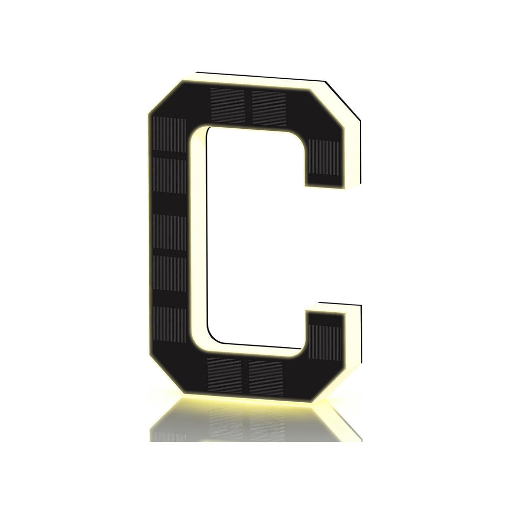 Black and gold solar house letter D with solar cells on the face and a warm glowing outline, angled view