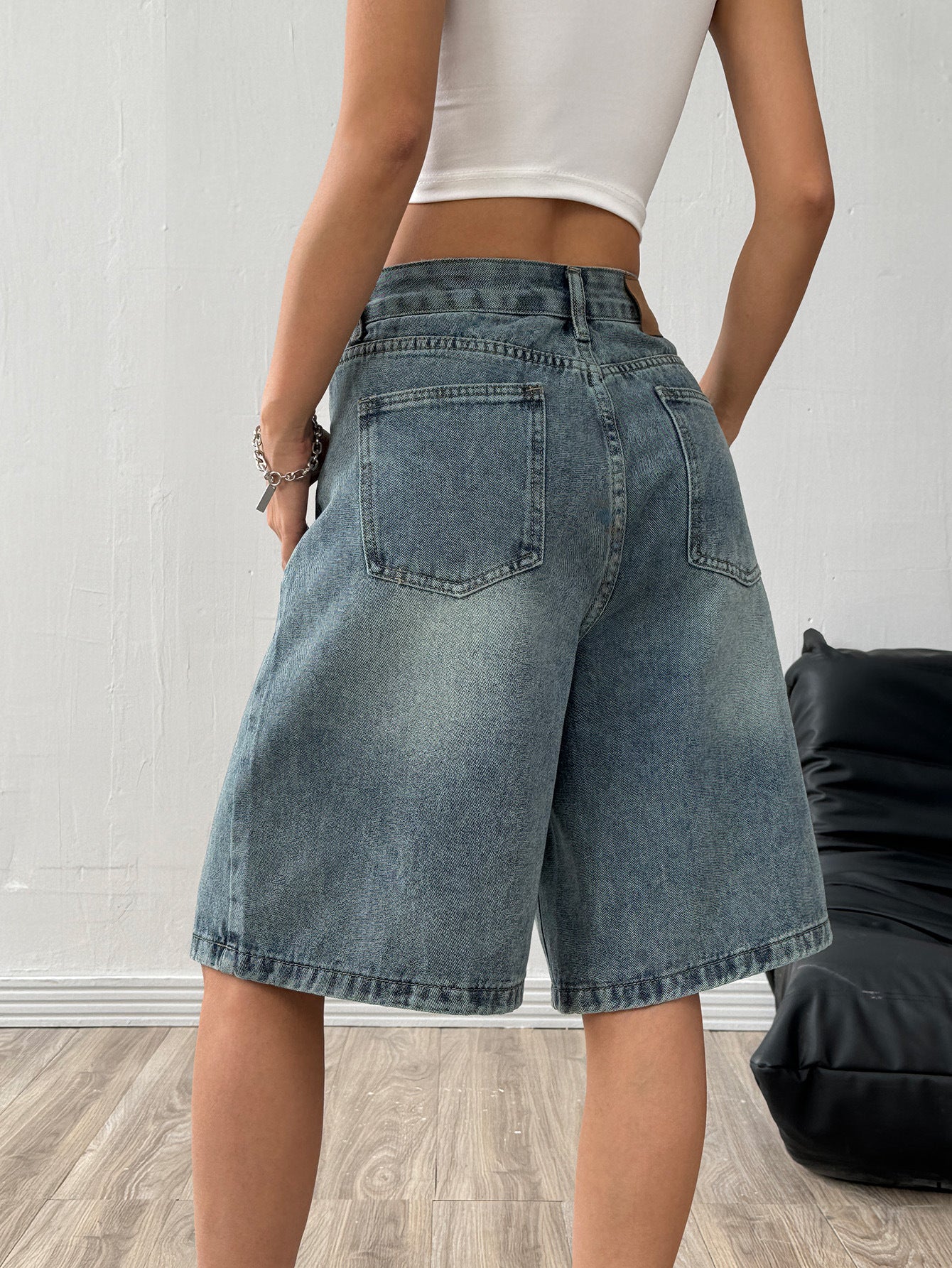 Side profile of the denim wide-leg shorts showing the wide hem and topstitched seam