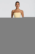 White strapless ruched gown worn showing the high thigh slit while standing